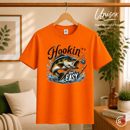 T-Shirt mit 'Hookin' Ain't Easy' Spruch | Dynamisches Barsch-Angelmotiv im Comic-Stil - StyleOne